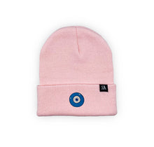 Load image into Gallery viewer, Blue Evil Eye embroidered on a pink acrylic beanie, with an RA Attire woven logo label. Featured on white background image.